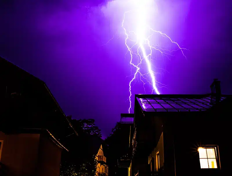 Lightning bolt strikes near a home in Connecticut during a summer storm at night