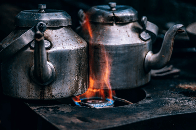 Flames under metal kettles on a gas stove