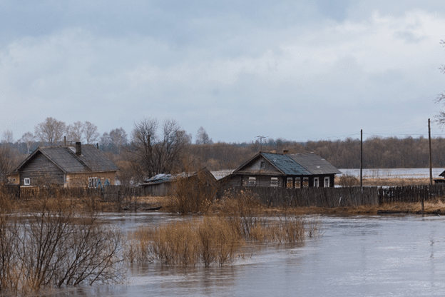Rural homes surrounded by rising floodwaters