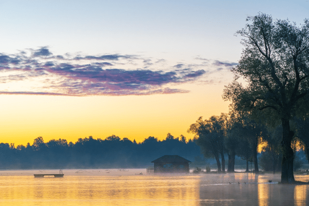 Flooded lakeside property at sunrise