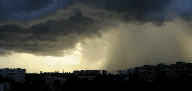 Dark storm clouds and heavy rain over residential buildings