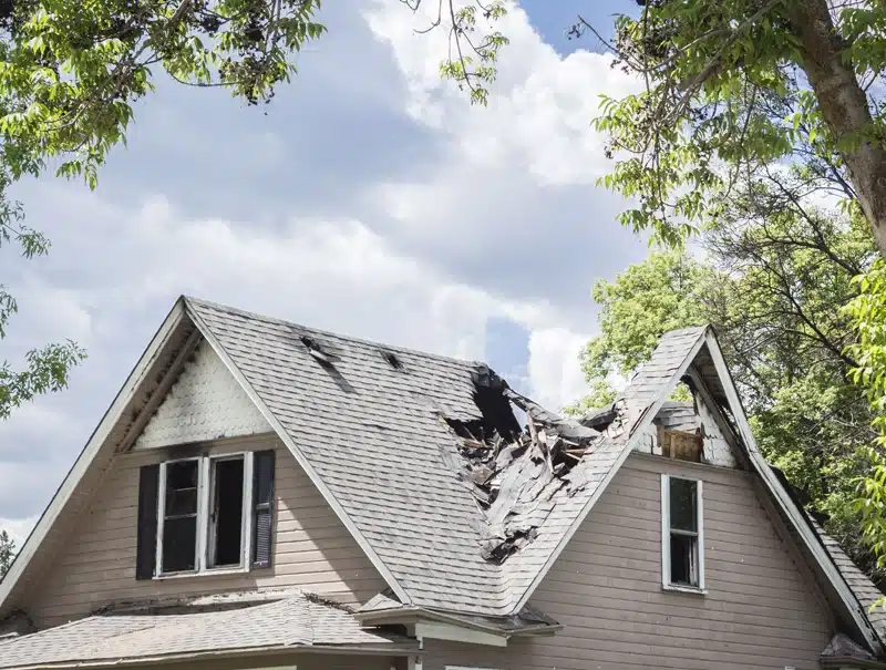 Damaged roof of a home after severe storm with broken shingles.