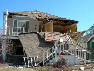Damaged home with collapsed roof and porch after a severe storm