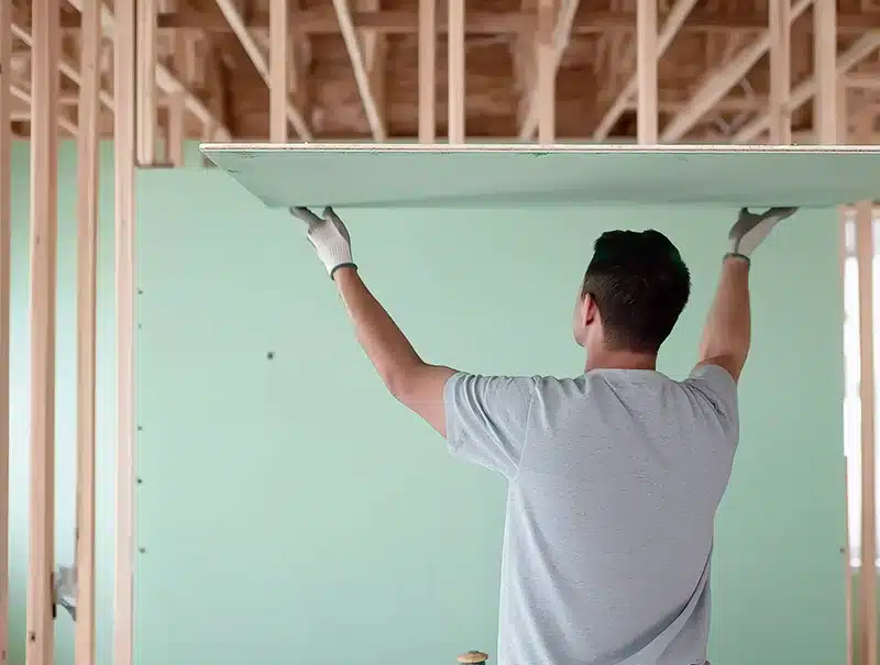 Contractor installing mold-resistant drywall inside a new home.