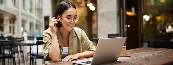 Smiling woman talking with insurance adjuster during online consultation on laptop
