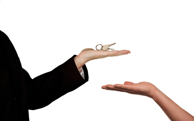 Landlord handing keys to a tenant during a move-in or move-out process.