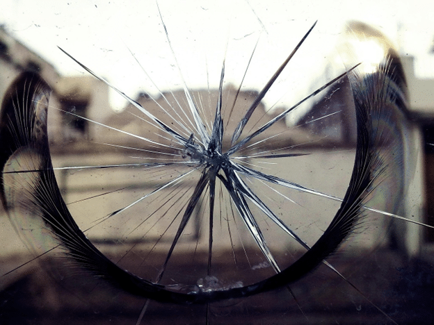 Close-up of a cracked window caused by impact or accidental damage.