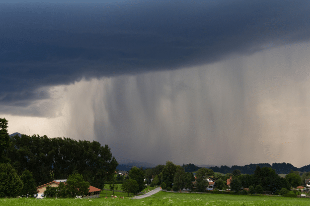 Dark storm clouds and heavy hail rainfall approaching a residential neighborhood.