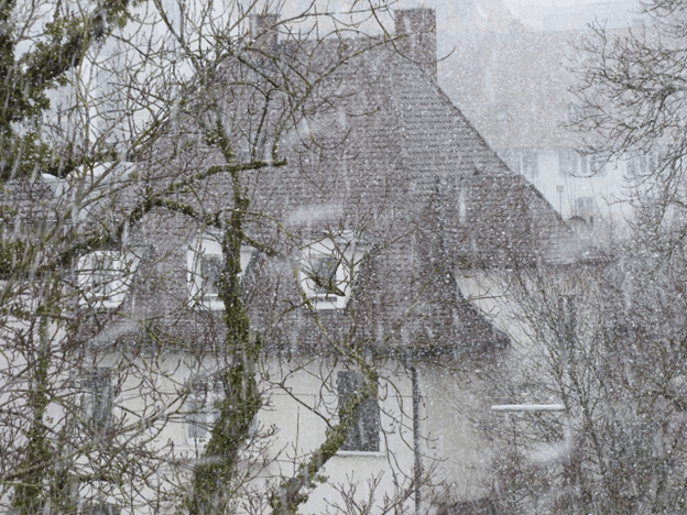 Heavy hail falling around a residential home during a winter storm.