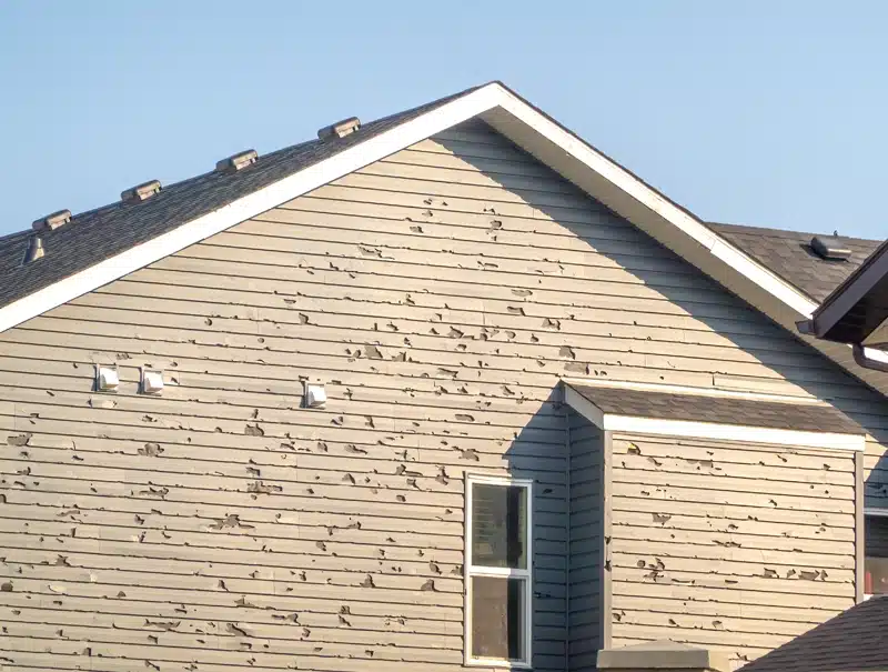Severe hail damage on home siding after a Connecticut storm